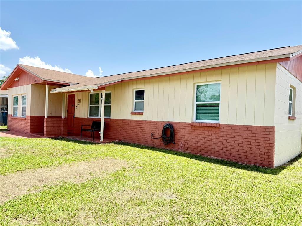 A single-story house with a brick and vertical siding exterior sits on a grassy lot — 3306 W BURKE STREET, TAMPA, FL