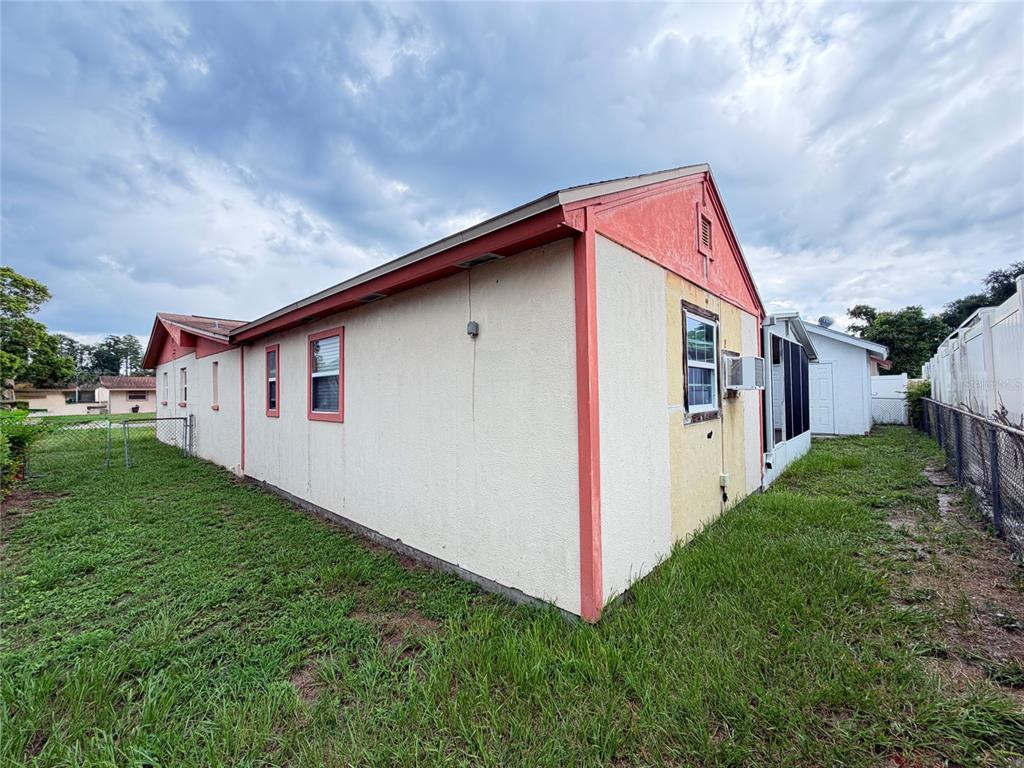 The exterior side and rear of a single-story house with a fenced yard — 3306 W BURKE STREET, TAMPA, FL