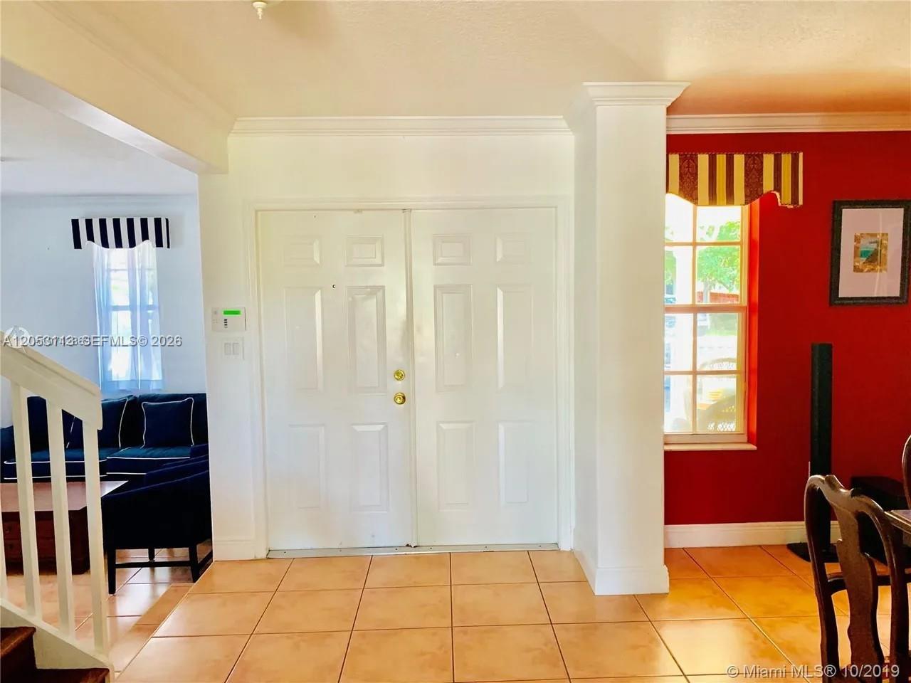 An entryway features white double doors, tiled flooring, and a red accent wall — 16141 SW 96th Ter, Miami FL 33196, MIAMI, FL