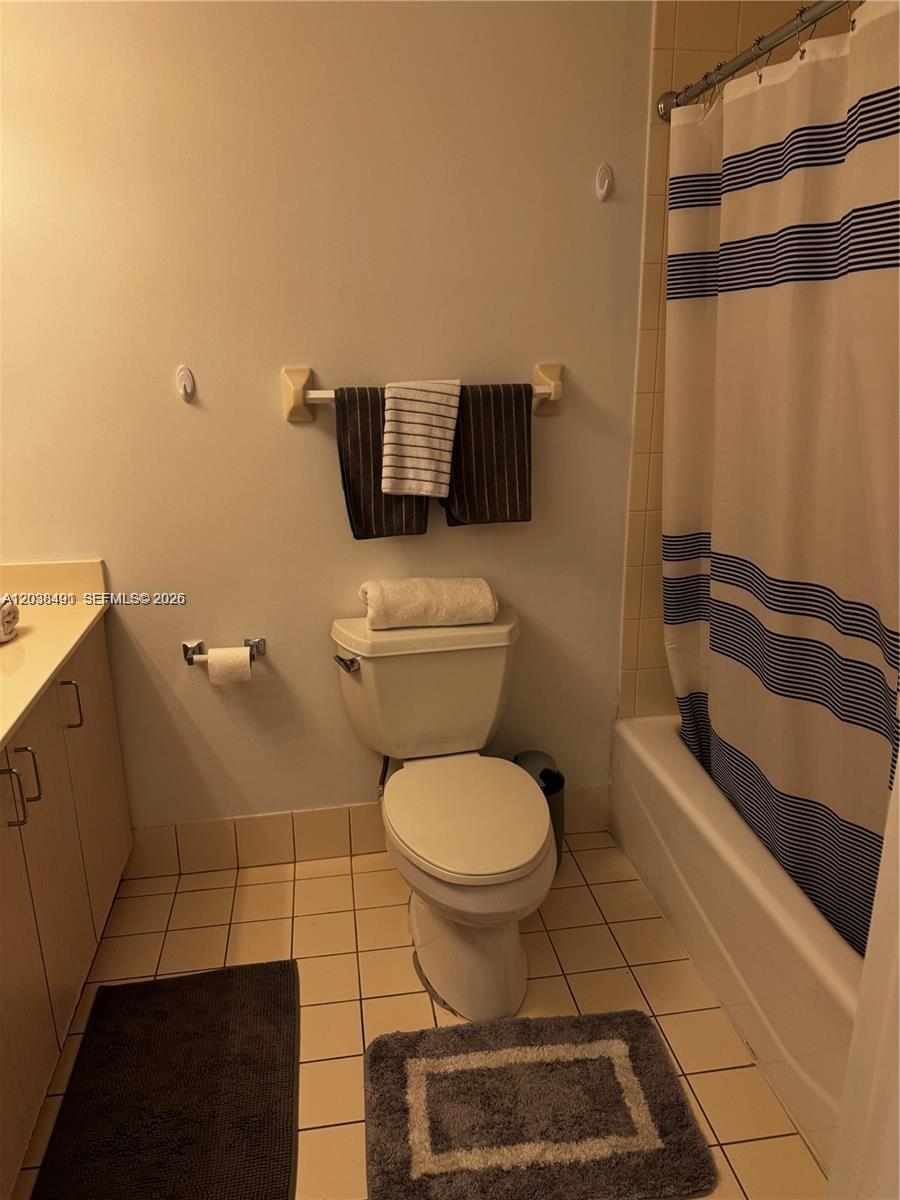 A bathroom features a toilet, a vanity, and a shower with a striped curtain — 185 SE 14th Ter # 1812, Miami FL 33131, MIAMI, FL