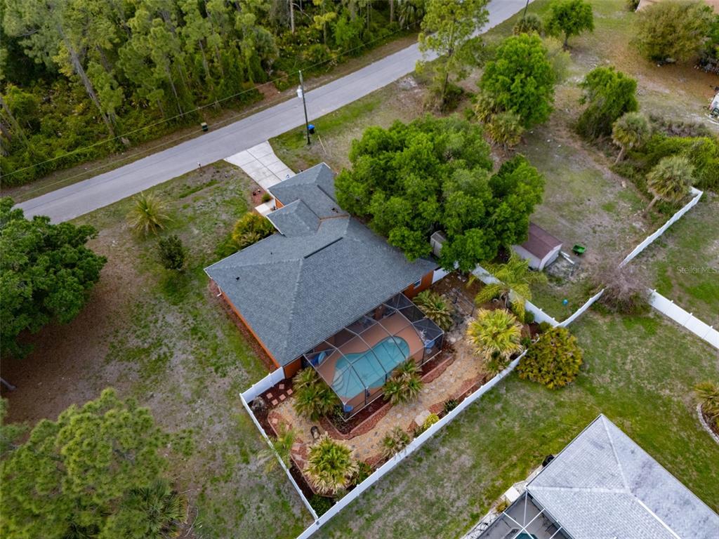 An aerial view shows a house with a screened-in pool and a fenced backyard — 2486 LAWYER TERRACE, NORTH PORT, FL