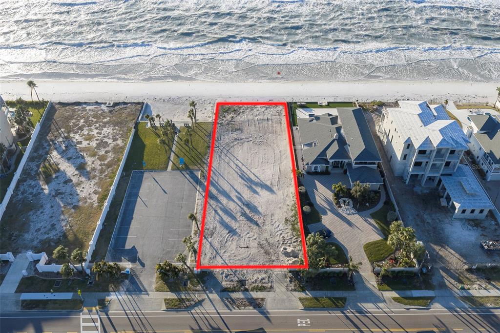 An aerial view shows a vacant rectangular beachfront lot outlined in red between two houses — 620.5 GULF BOULEVARD, BELLEAIR SHORE, FL