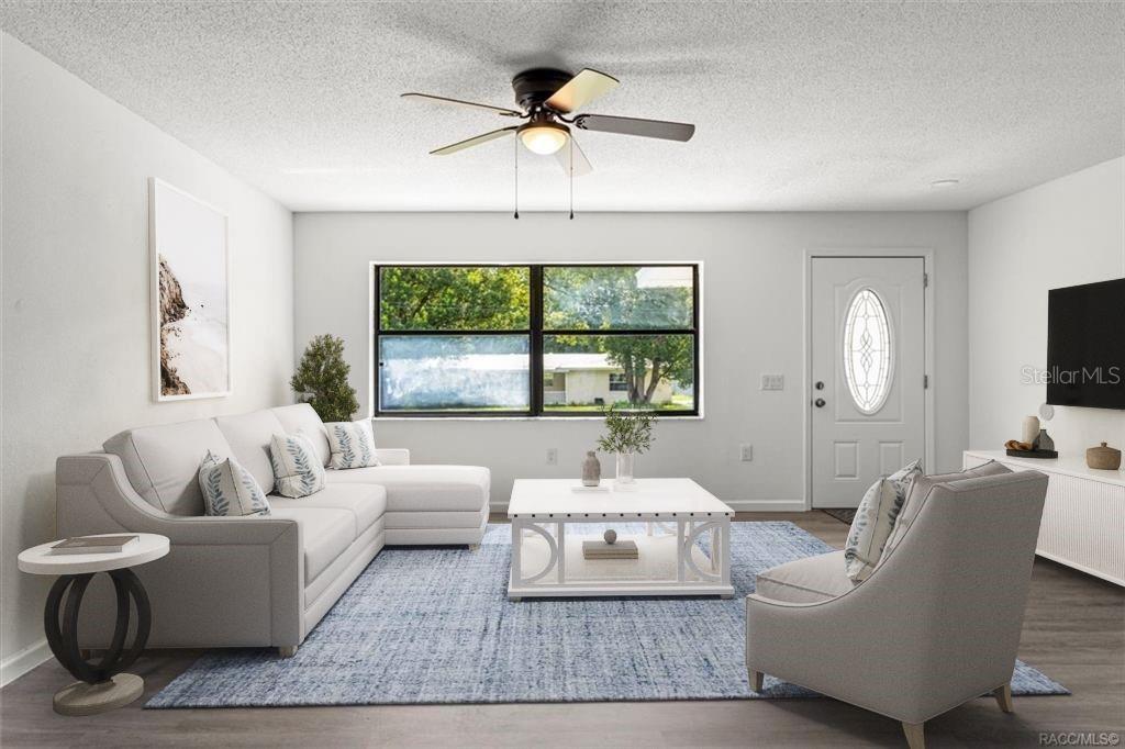 A living room features a white sectional sofa, a blue area rug, and a ceiling fan — 5700 S CALGARY TERRACE, INVERNESS, FL