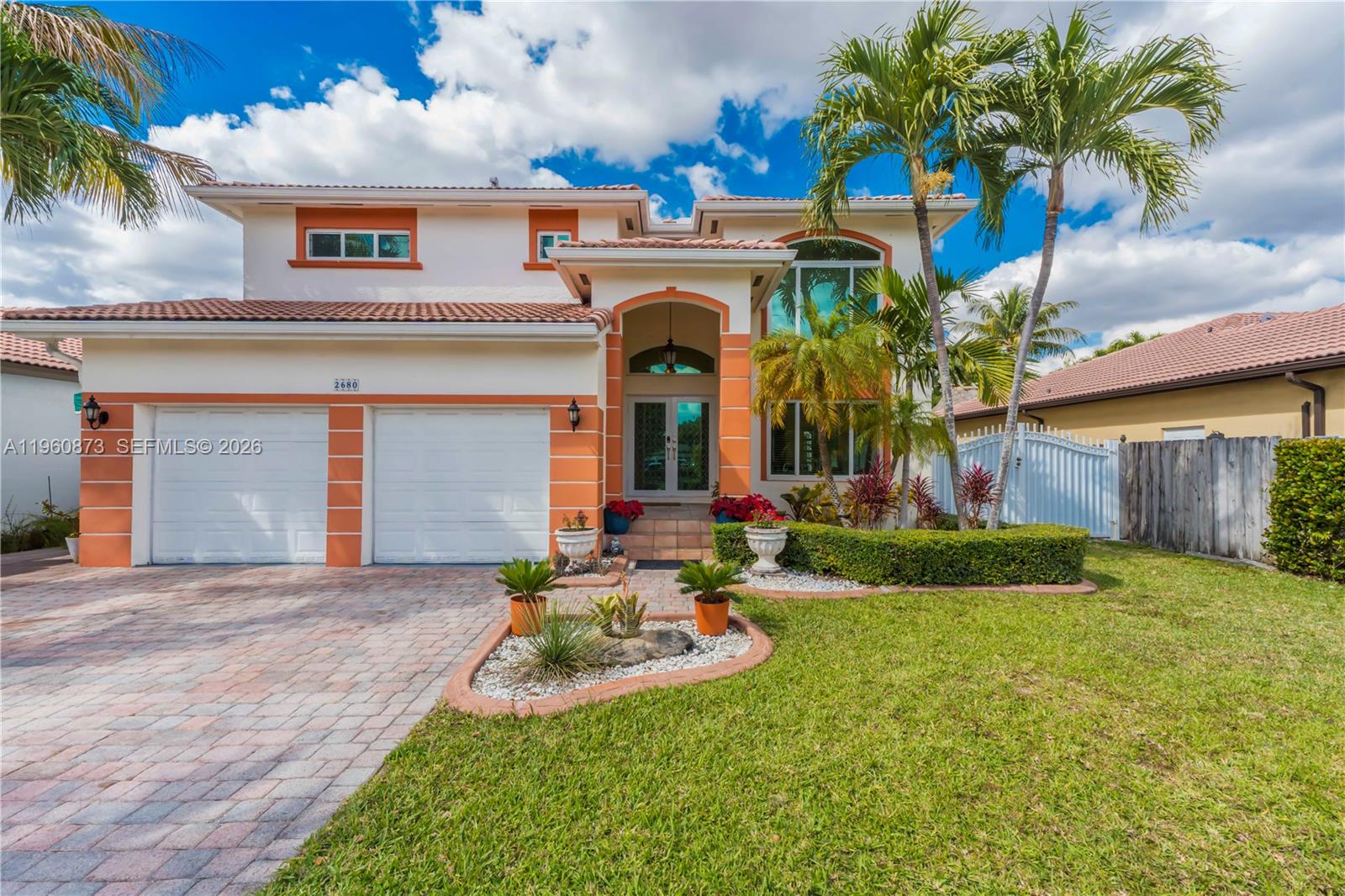 A two-story house with a two-car garage, orange trim, and palm trees in the front yard — 2680 SW 142nd Ave, Miami FL 33175, MIAMI, FL
