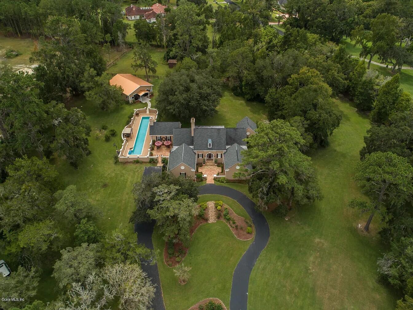 An aerial view shows a house with a lap pool and detached garage on acreage — 2030 SW 61st Lane Road, Ocala FL 34471, OCALA, FL