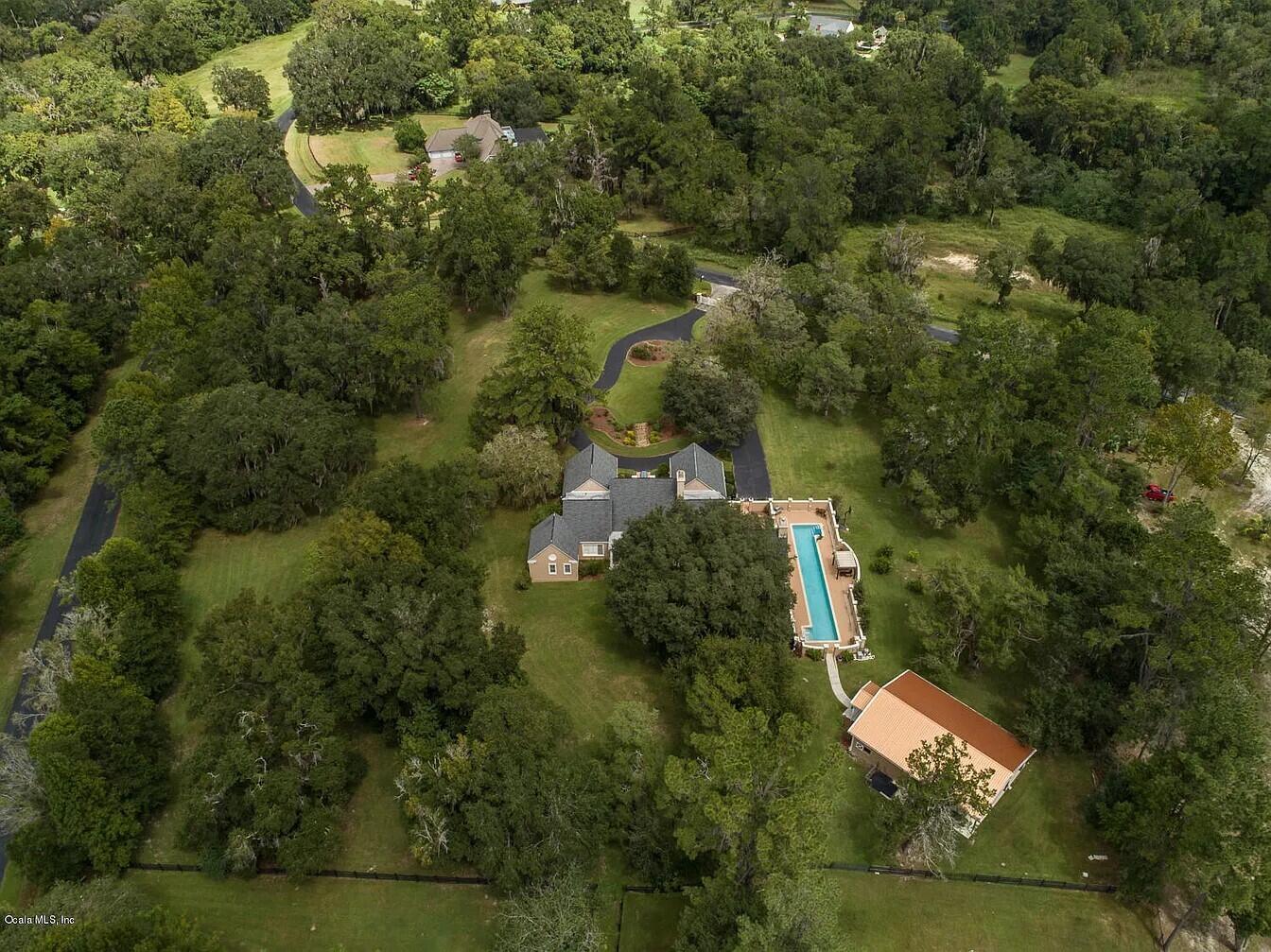 An aerial view shows a house with a long swimming pool and a detached building — 2030 SW 61st Lane Road, Ocala FL 34471, OCALA, FL