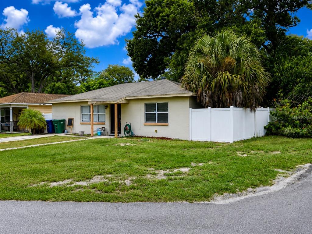 A single-story house with a light-colored exterior, a palm tree, and a white privacy fence — 712 N CASTLE COURT, TAMPA, FL