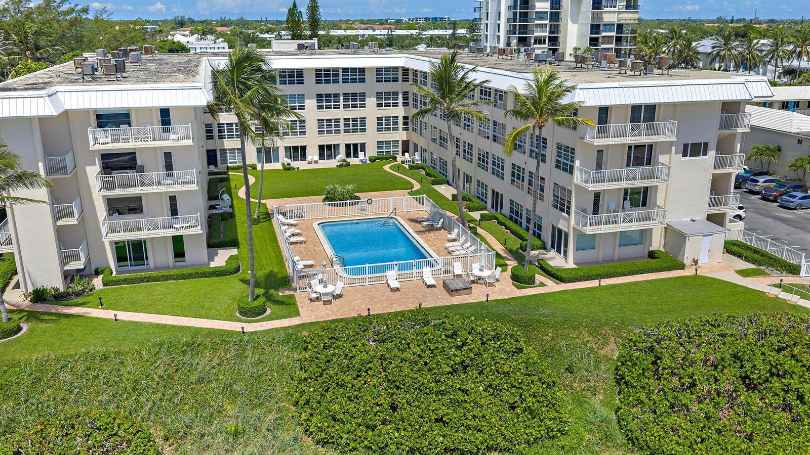 An aerial view shows a multi-story apartment building with a central courtyard and swimming pool — 3851 N Ocean Boulevard # 202, Gulf Stream FL 33483, GULF STREAM, FL