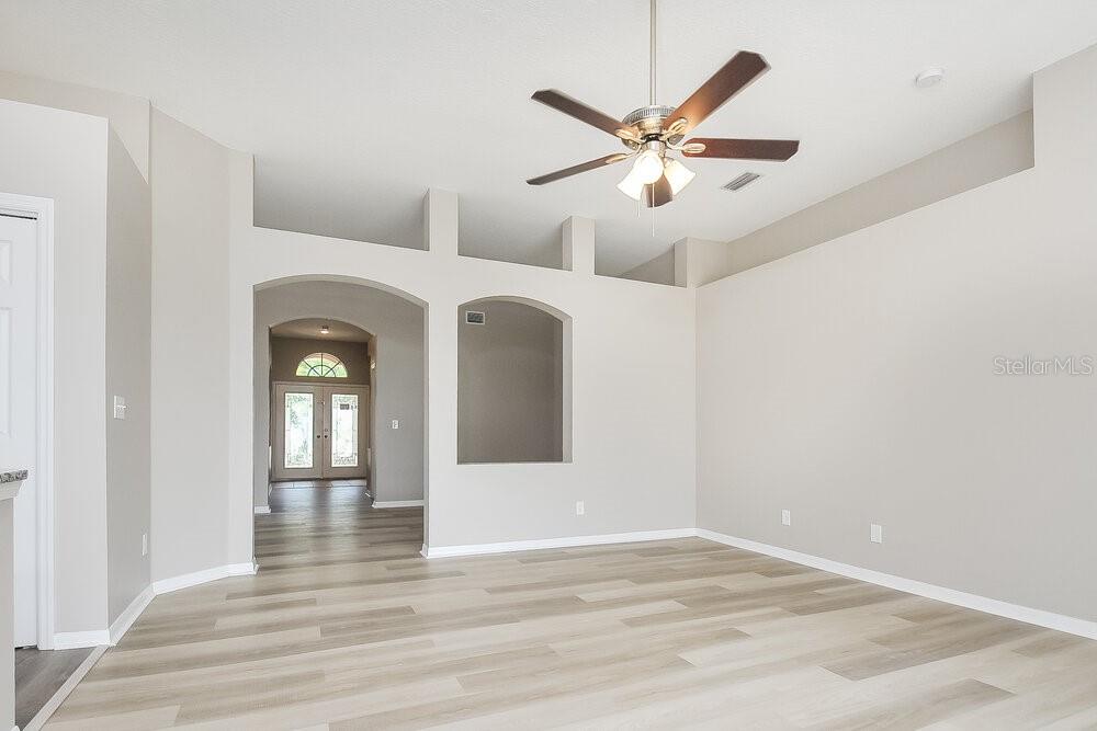 A living room with light wood-look flooring, vaulted ceilings, and a ceiling fan — 1221 BARCLAY WOOD DRIVE, RUSKIN, FL