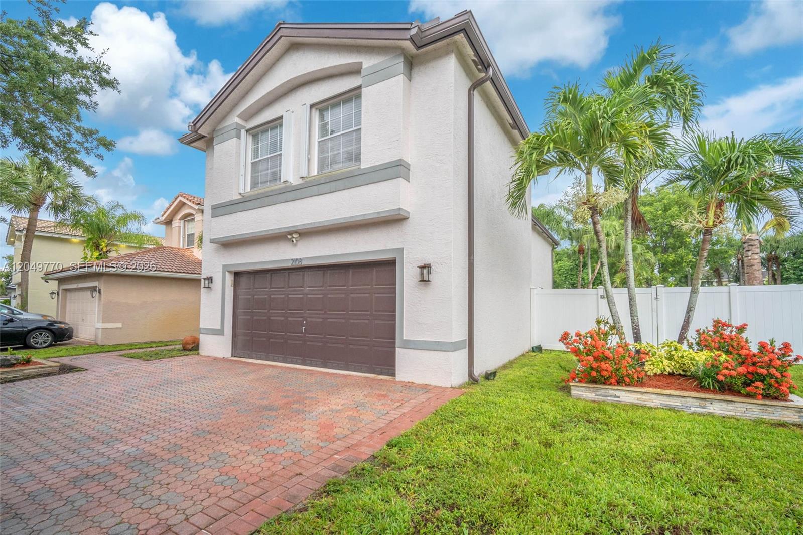 A two-story house with a brown garage door, brick driveway, and palm trees in front — 2108 SW 151st Ave, Miramar FL 33027, MIRAMAR, FL