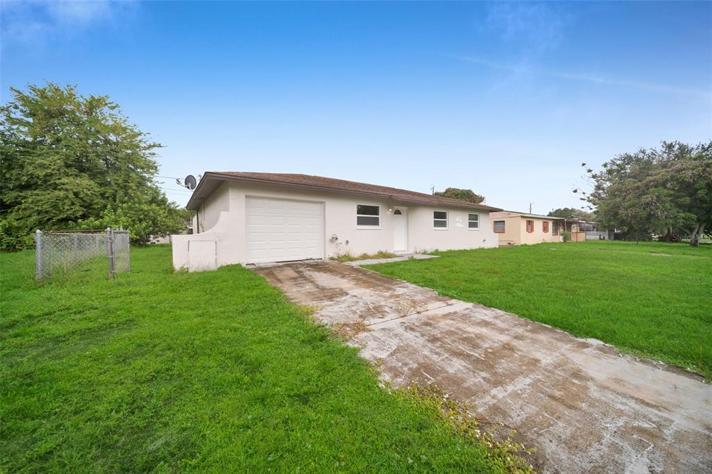 A single-story house with a white exterior, a one-car garage, and a concrete driveway — 38 ABACO STREET, LEHIGH ACRES, FL