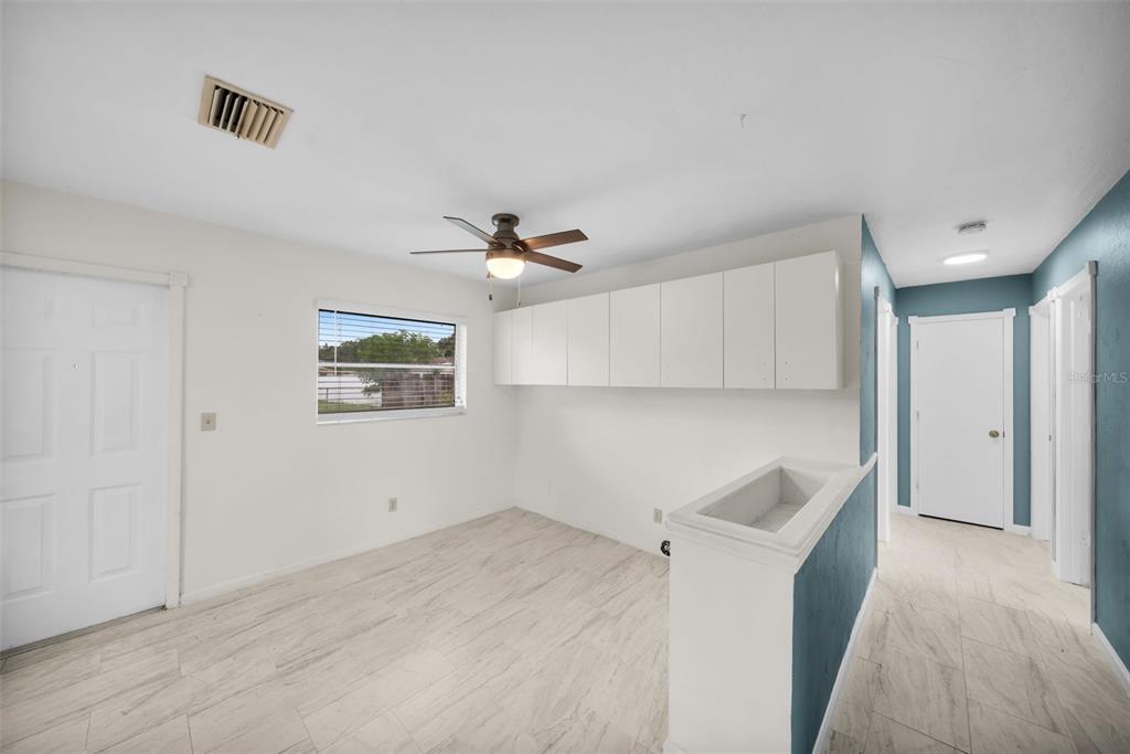A room with white walls, tile flooring, a ceiling fan, and white upper storage cabinets — 38 ABACO STREET, LEHIGH ACRES, FL