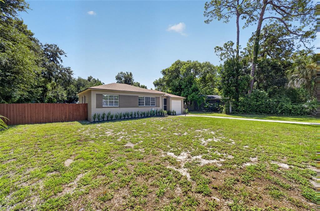 A single-story house with a tan exterior, a brown roof, and a large front lawn — 2403 KEY AVENUE, SANFORD, FL