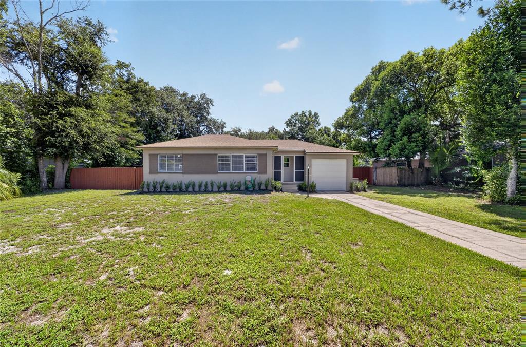 A single-story house with a tan exterior, white garage door, and a large front lawn — 2403 KEY AVENUE, SANFORD, FL