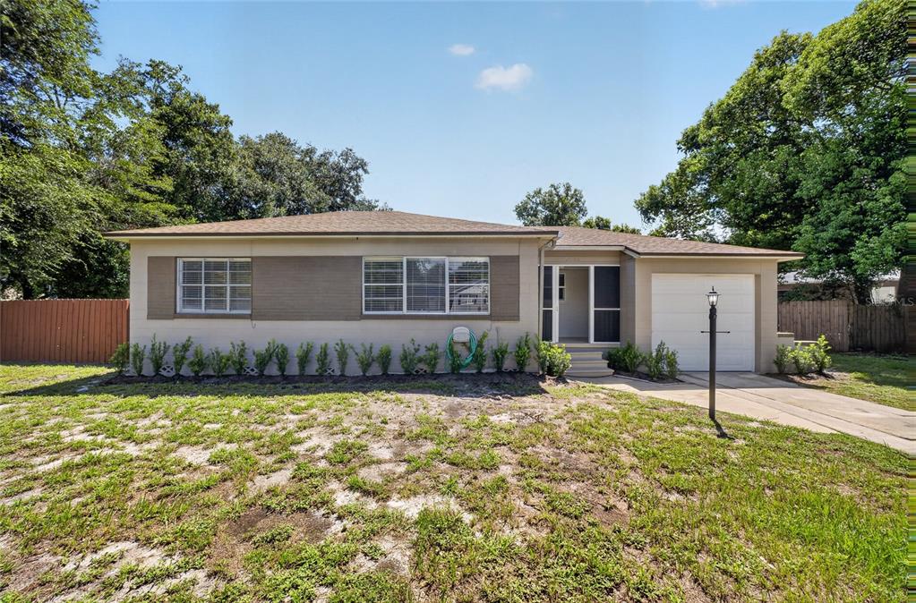A single-story house with a beige exterior, a one-car garage, and a front lawn — 2403 KEY AVENUE, SANFORD, FL
