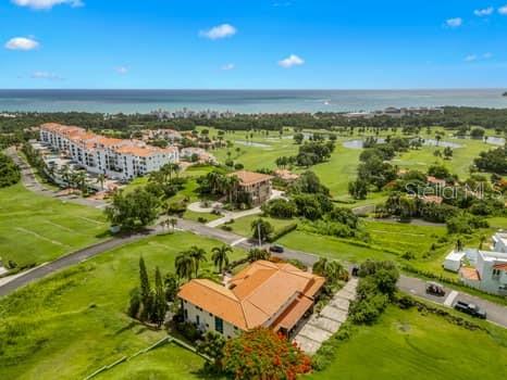 An aerial view shows a large house with a terracotta roof surrounded by golf course grounds — 13 MIRADOR NE UNIT 13, RIO GRANDE, PR