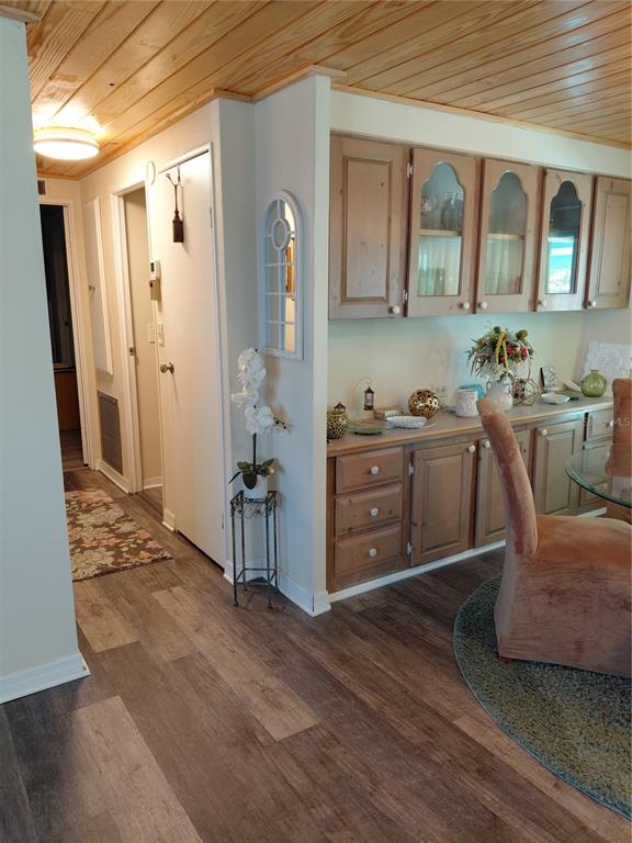 A dining area features wood-paneled ceilings, light wood cabinetry, and wood-look flooring — 1451 BLUE HERON DRIVE, ENGLEWOOD, FL