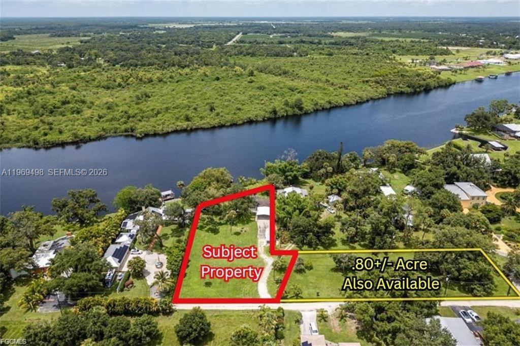 An aerial view shows a waterfront property outlined in red next to an adjacent lot — 2030 Ft Denaud Rd, La Belle FL 33935, LA BELLE, FL