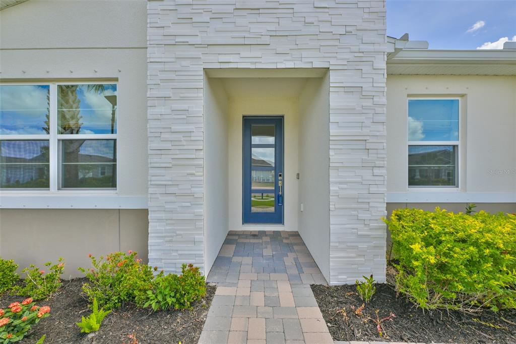 A blue front door is centered within a white stone-clad entryway of a house — 12342 54TH STREET E, PARRISH, FL