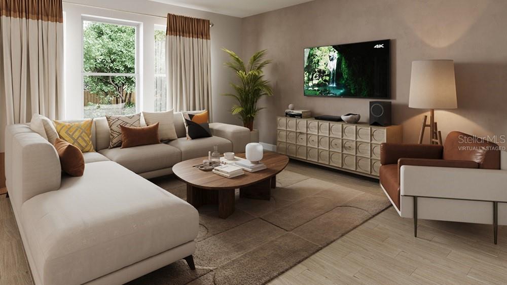 This is a virtually staged living room featuring a sectional sofa, coffee table, and television — 7812 CENTAURUS WAY, SARASOTA, FL