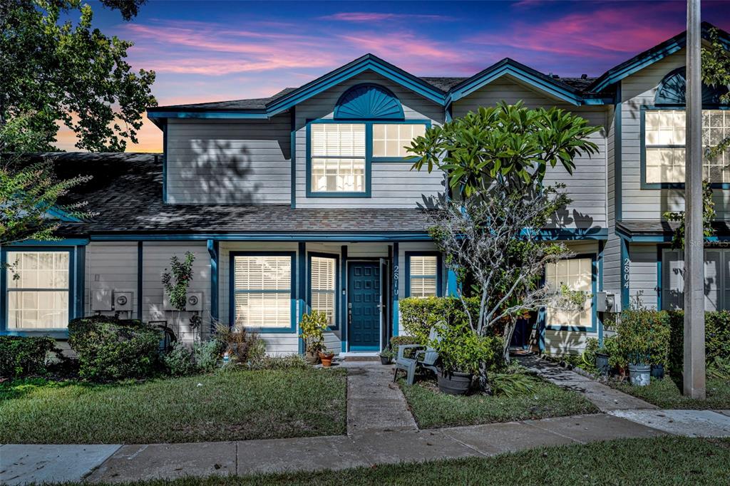 A two-story townhouse with light gray siding, blue trim, and a front walkway — 2810 CORNERSTONE COURT, APOPKA, FL