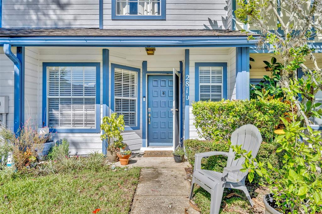 A blue front door with a white frame sits at the entrance of a house — 2810 CORNERSTONE COURT, APOPKA, FL
