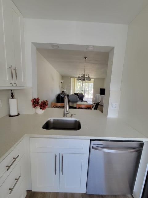 A kitchen sink and dishwasher are set into a white countertop with white cabinets — 6650 S Oriole Boulevard # 4080, Delray Beach FL 33446, DELRAY BEACH, FL