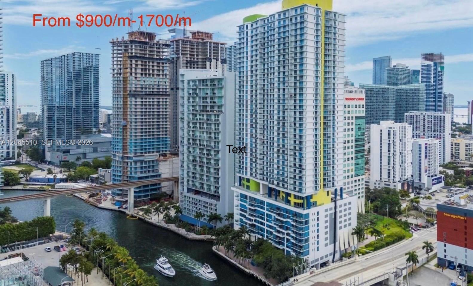 An aerial view of a high-rise building complex situated along a canal in a city — 175 SW 7th St # 1212, Miami FL 33130, MIAMI, FL