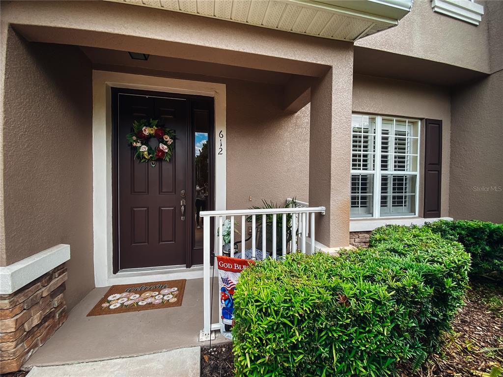 A front entrance features a dark brown door with a wreath and a small porch — 612 ROGUE DRIVE, LONGWOOD, FL