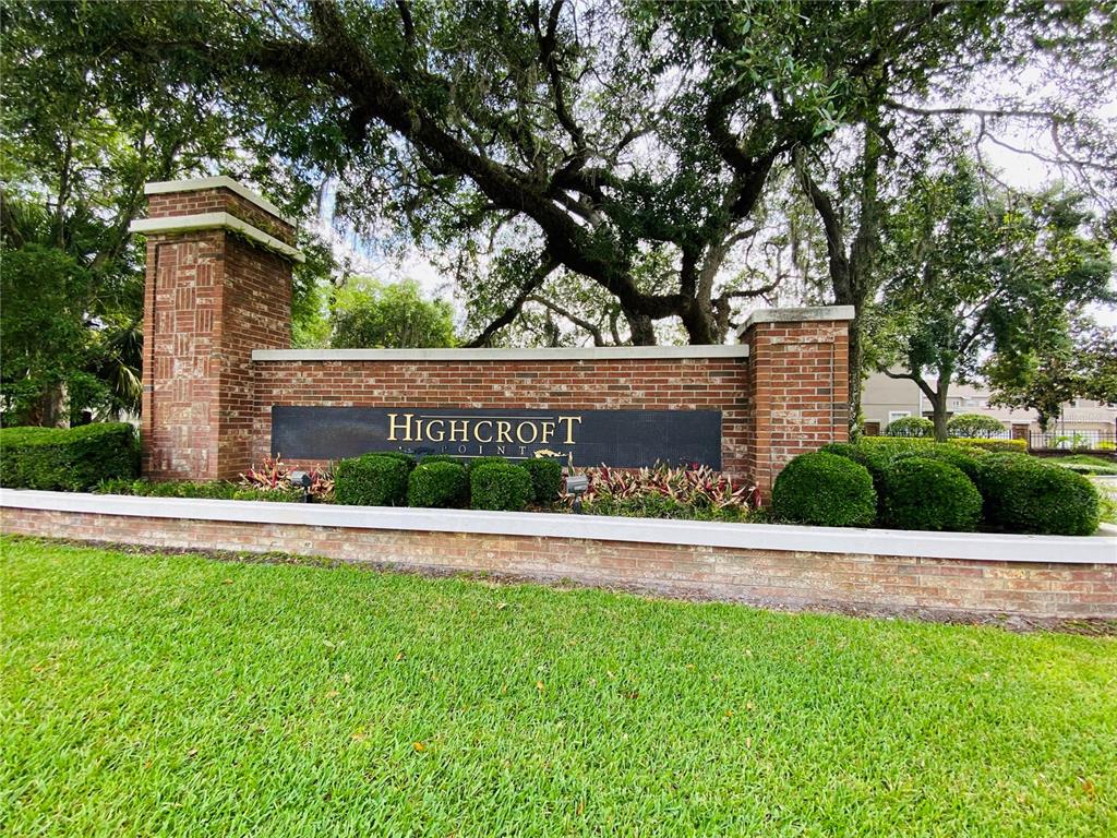 A brick entrance sign for Highcroft Point stands behind a manicured lawn and landscaping — 612 ROGUE DRIVE, LONGWOOD, FL