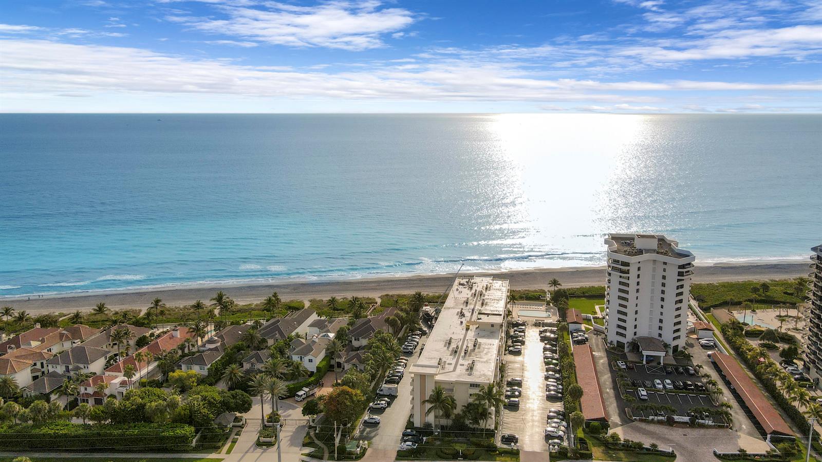 An aerial view shows a coastal residential area with a beach, ocean, and apartment buildings — 630 Ocean Drive # 102, Juno Beach FL 33408, JUNO BEACH, FL