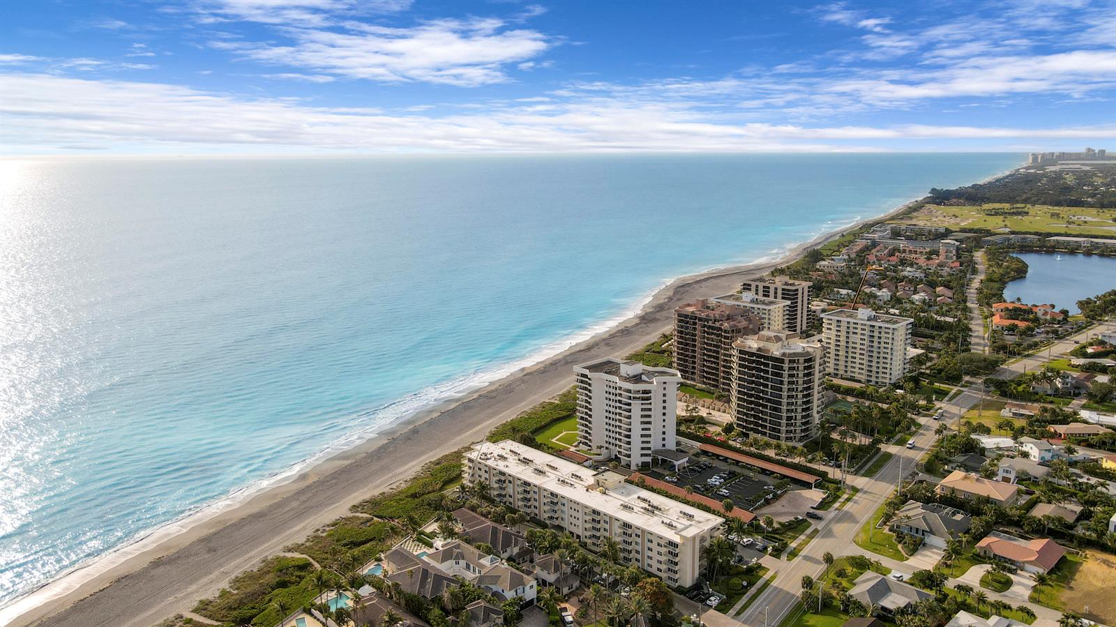 An aerial view of a coastal beach with high-rise condominiums and residential homes nearby — 630 Ocean Drive # 102, Juno Beach FL 33408, JUNO BEACH, FL