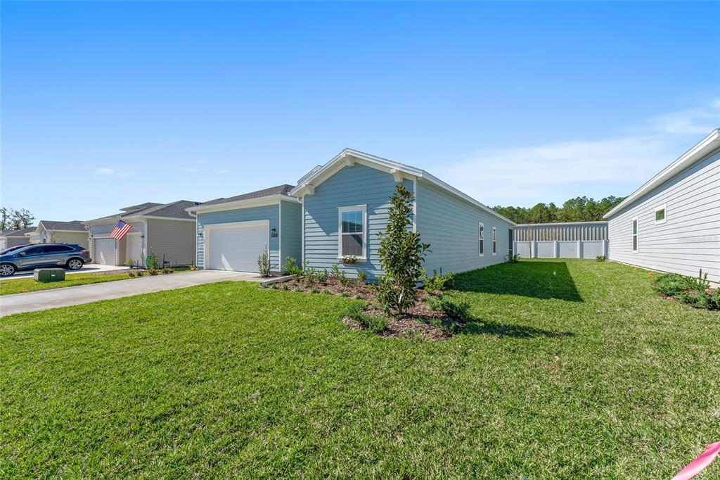 A light blue single-story house with a two-car garage and a landscaped front yard — 7931 SW 74TH LOOP, OCALA, FL