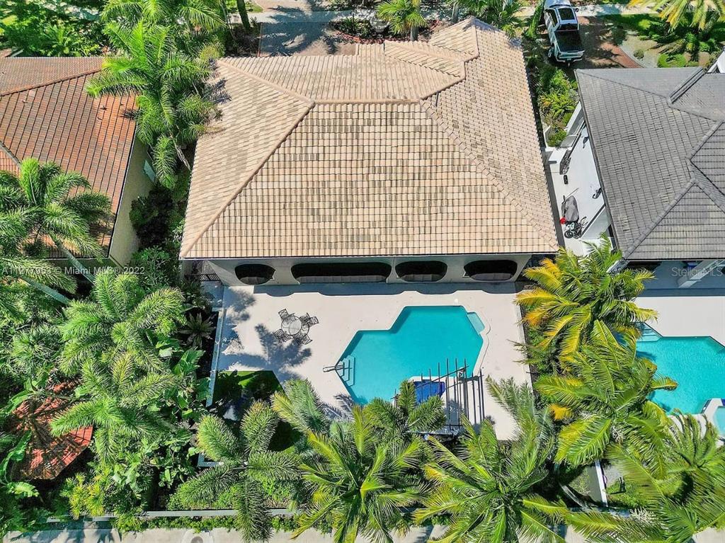 An aerial view of a house with a tiled roof, a swimming pool, and palm trees — 15945 NW 82ND COURT, MIAMI LAKES, FL