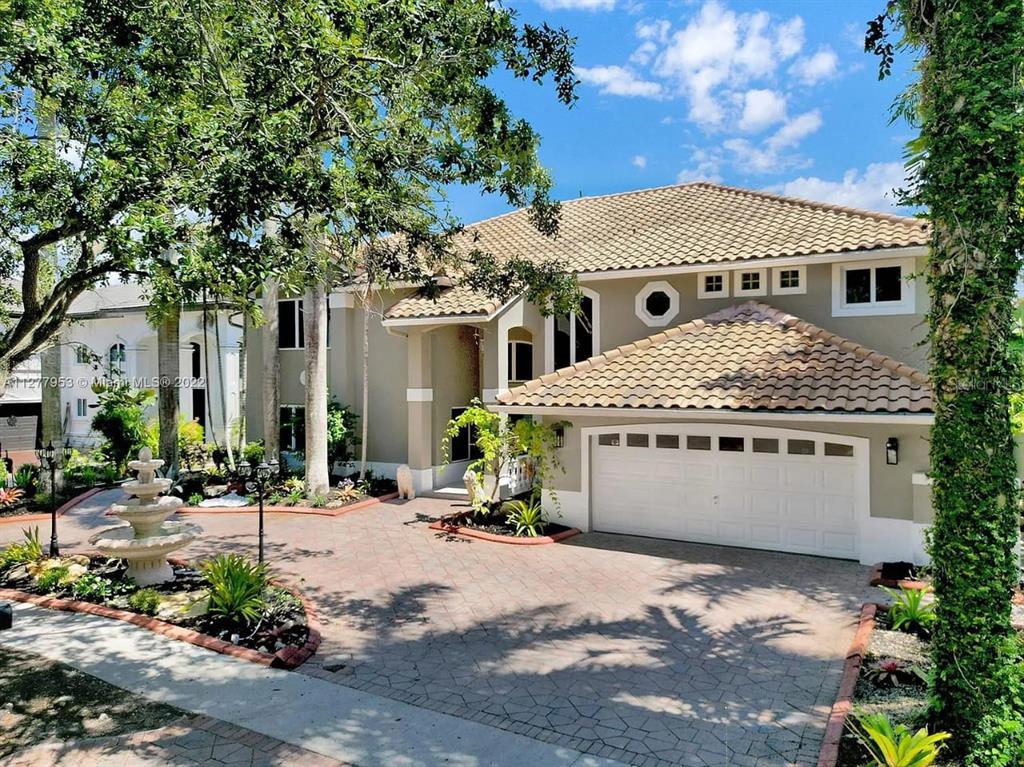 A two-story house with a tiled roof, a paved driveway, and a front yard fountain — 15945 NW 82ND COURT, MIAMI LAKES, FL