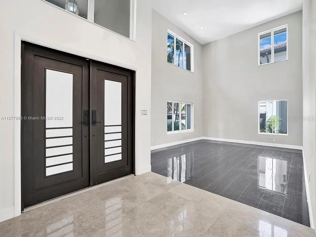 A double-door entryway leads into a two-story foyer with tile and dark wood flooring — 15945 NW 82ND COURT, MIAMI LAKES, FL