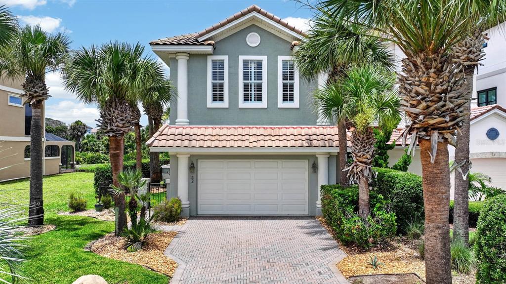 A two-story house with a gray exterior, a tiled roof, and a paved driveway — 32 NORTHSHORE AVENUE, PALM COAST, FL