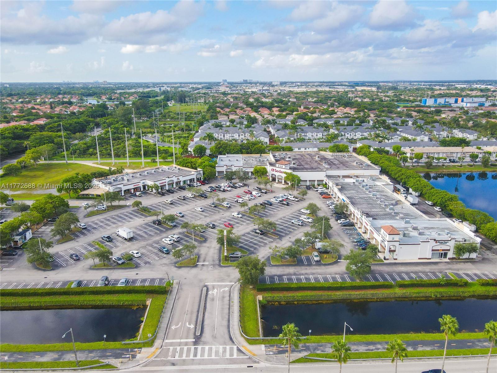 An aerial view shows a commercial shopping center with a large parking lot and surrounding landscaping — 10750 NW 58th St, Doral FL 33178, DORAL, FL
