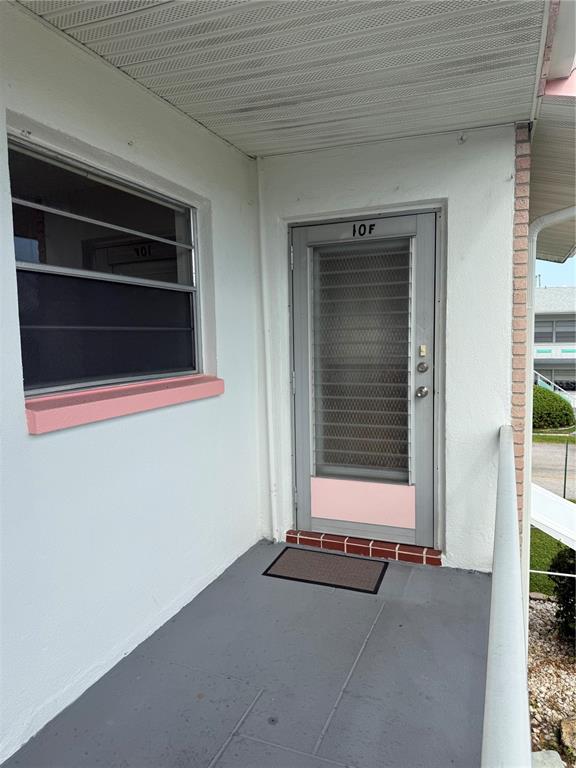 An exterior view of a building entrance with a grey door labeled 10F and a window — 5900 21ST STREET N UNIT 10, ST PETERSBURG, FL
