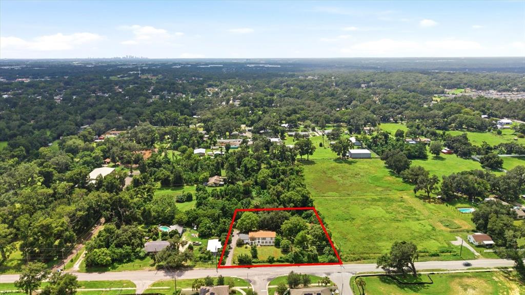 A long, single-story white house sits on a large grassy lot with a paved driveway — 403 S PARSONS AVENUE, SEFFNER, FL