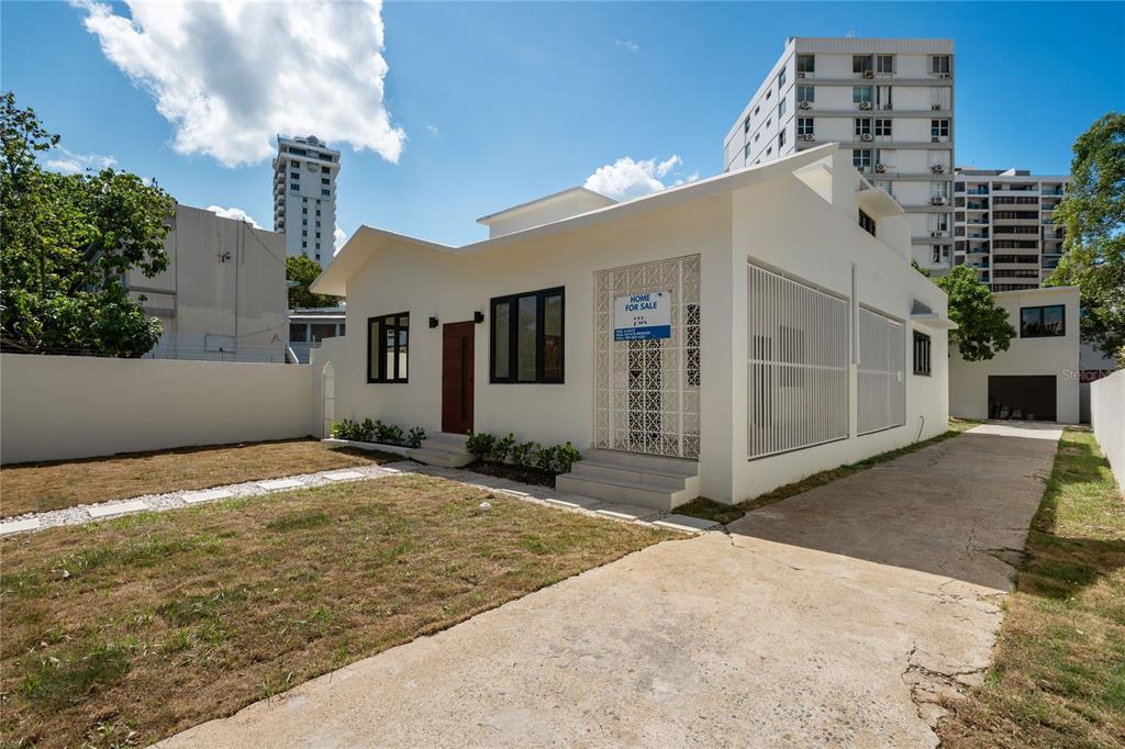 A white single-story house with a concrete driveway and a front yard under a blue sky — 1207 LUCHETTI STREET, SAN JUAN, PR