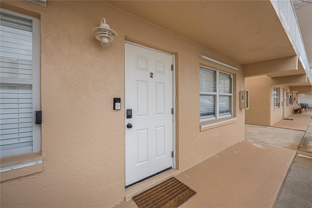 The exterior view shows a tan building with a white door labeled number two — 3724 S ATLANTIC AVENUE UNIT 20, DAYTONA BEACH, FL