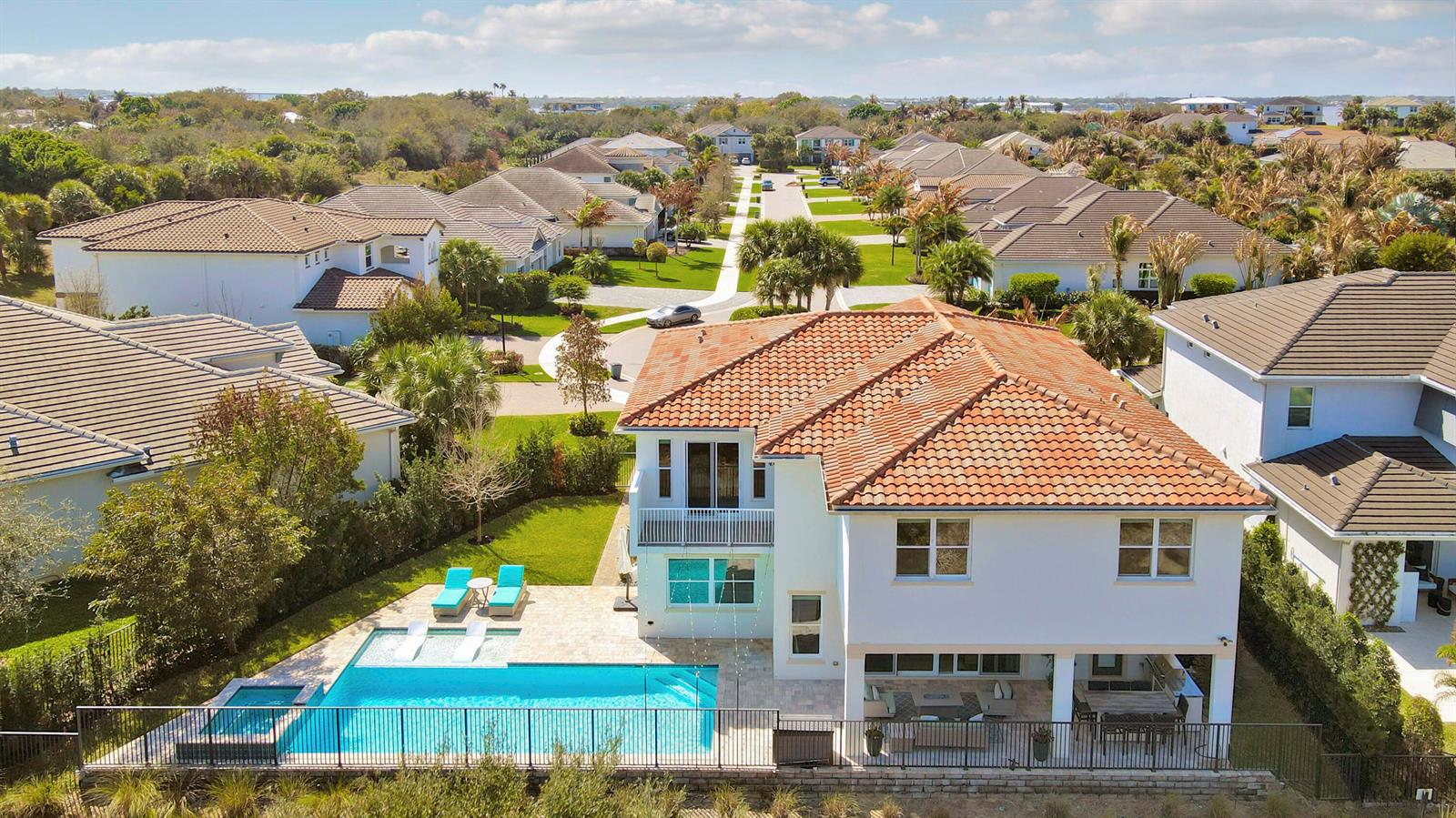 An aerial view of a two-story house with a backyard pool and patio area — 2475 NE Evinrude Circle, Jensen Beach FL 34957, JENSEN BEACH, FL