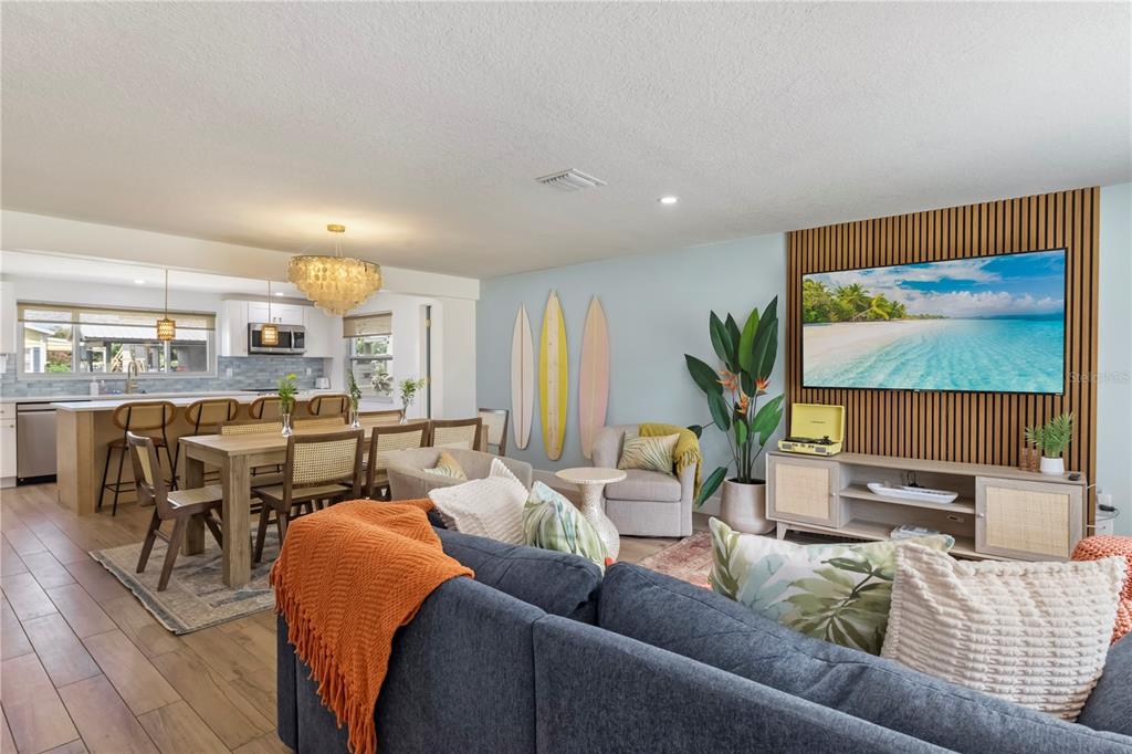A living room and dining area feature wood-look tile floors and a slatted wood wall — 103 W NORTH BRANCH ROAD, RUSKIN, FL
