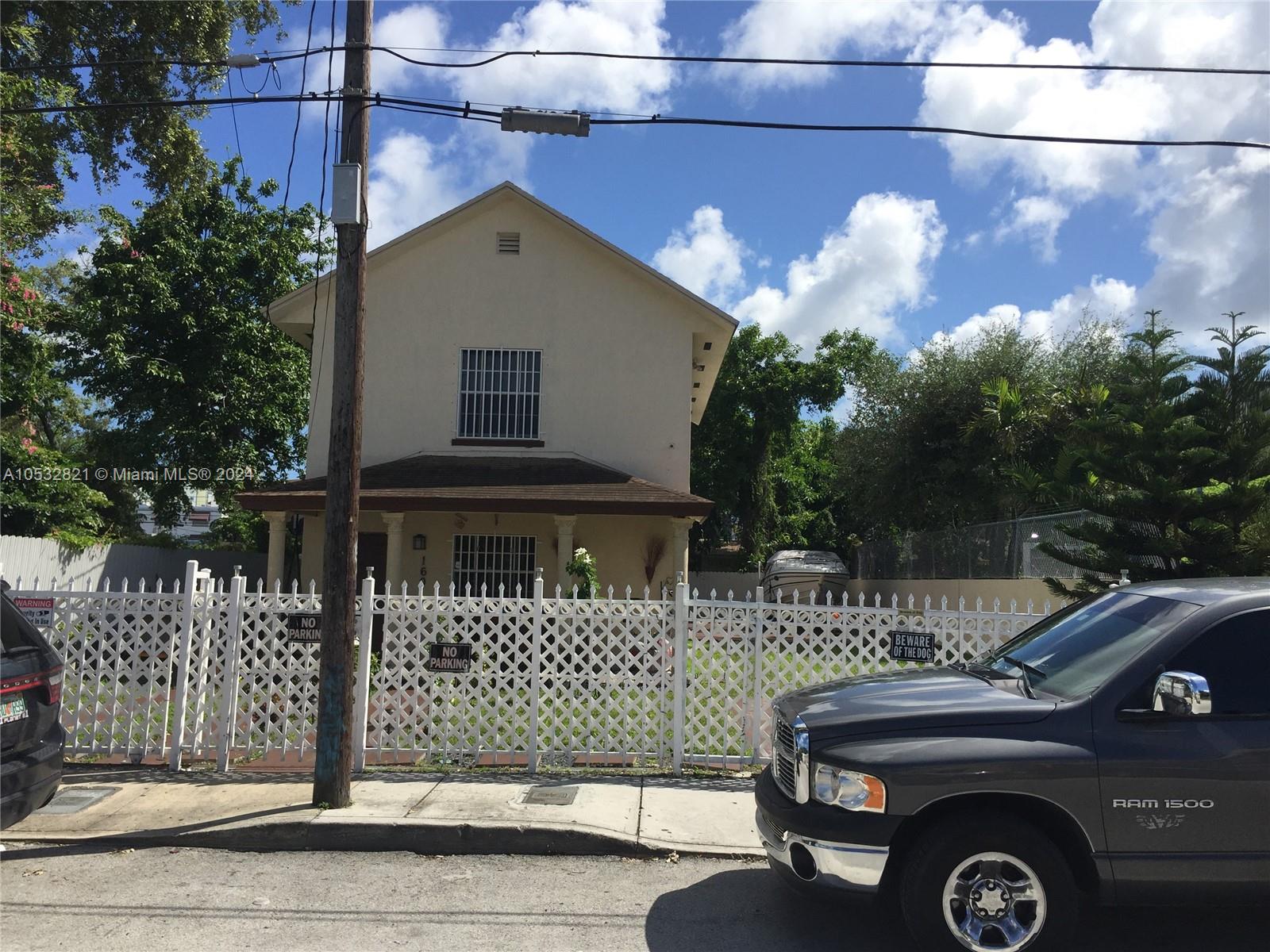 A two-story house with a white lattice fence and a truck parked in front — 160 NW 27th St, Miami FL 33127, MIAMI, FL