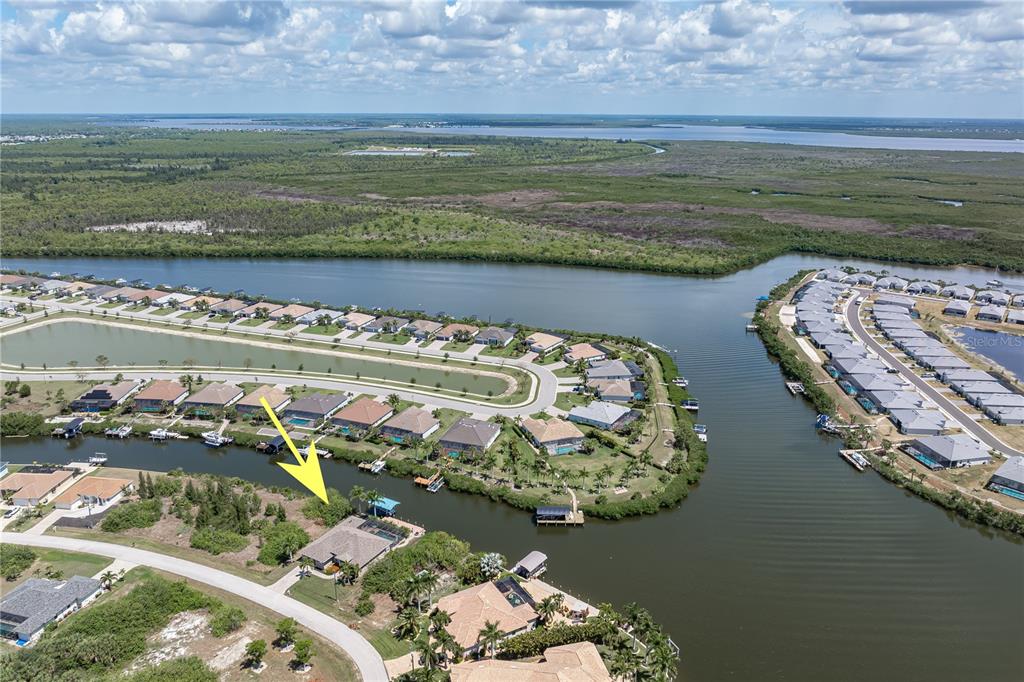 An aerial view shows a waterfront house with a boat dock on a canal — 15156 LEIPZIG CIRCLE, PORT CHARLOTTE, FL