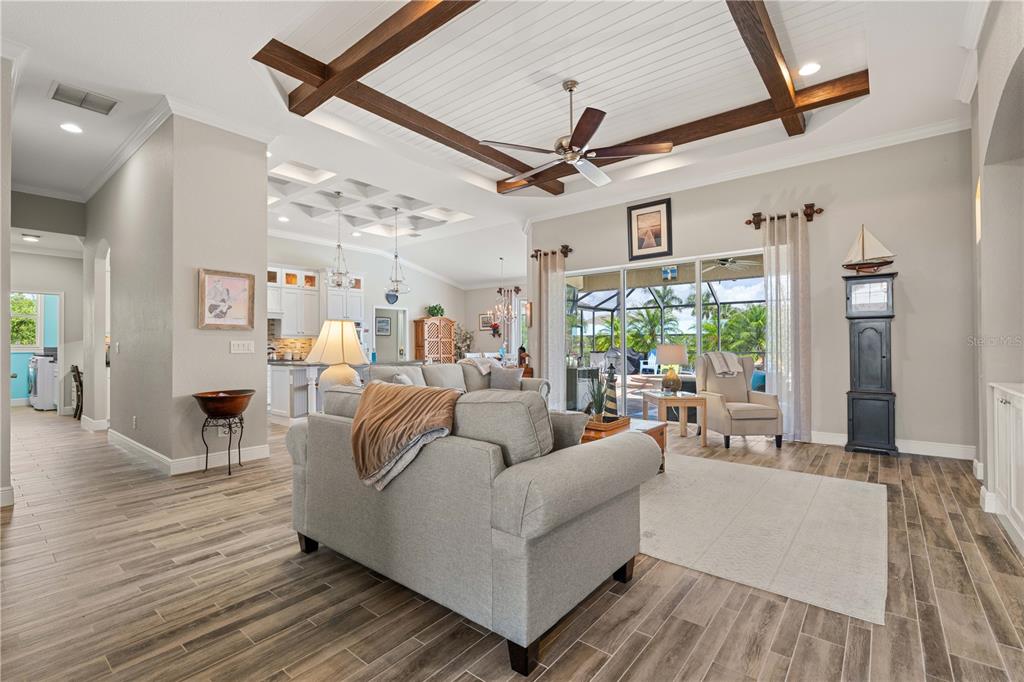 A living room features a coffered ceiling with wood beams, tile flooring, and sliding glass doors — 15156 LEIPZIG CIRCLE, PORT CHARLOTTE, FL