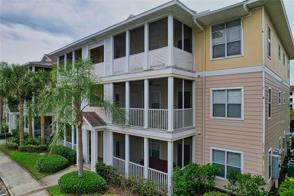 A three-story apartment building features screened-in balconies and tan horizontal siding — 4802 51ST STREET W UNIT 510, BRADENTON, FL