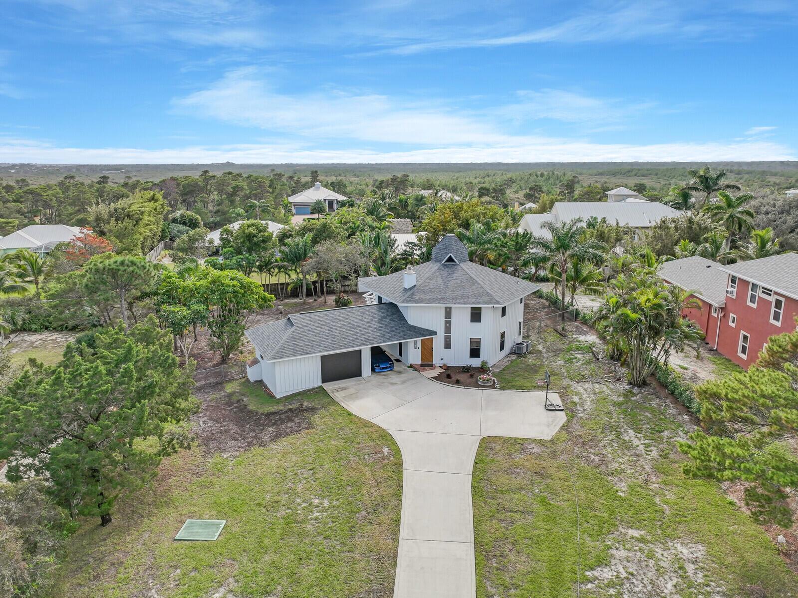 An aerial view shows a white house with a gray roof and a concrete driveway — 9752 SE Highborne Way, Hobe Sound FL 33455, HOBE SOUND, FL