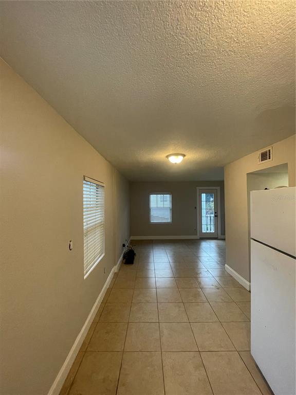 A view of a tiled kitchen area leading to a living space with a back door — 727 1/2 EDGEWATER DRIVE, ORLANDO, FL
